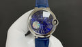 Round wristwatch with blue dial, Roman numerals, and blue leather strap