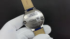 Wristwatch caseback on white gloves with stainless steel back and markings