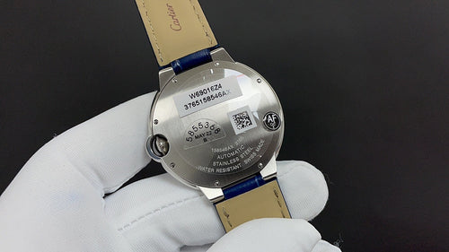Wristwatch caseback on white gloves with stainless steel back and markings