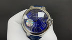 Round automatic wristwatch with blue dial, Roman numerals, and blue leather strap