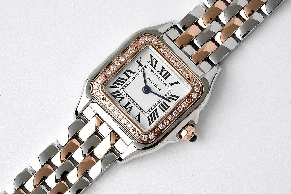 Cartier watch with diamond-set bezel, Roman numerals dial, and two-tone link bracelet