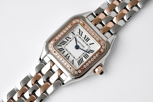 Cartier watch with diamond-set bezel, Roman numerals dial, and two-tone link bracelet
