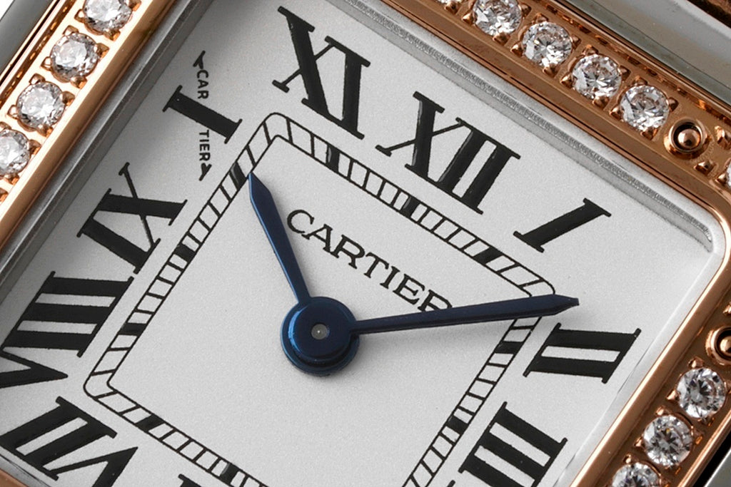 Close-up of Cartier watch dial with Roman numerals and blue center second hand