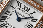 Close-up of Cartier watch dial with Roman numerals and blue center second hand