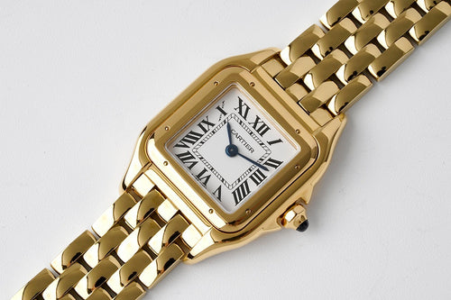 Gold-tone Cartier Tank watch, angled view with Roman numeral dial and link bracelet