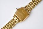 Gold-tone Cartier Tank watch caseback with engraved markings on metal bracelet
