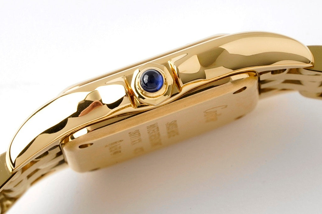 Gold-tone Cartier watch crown with blue gem and polished case edge