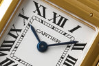 Gold-tone Cartier Tank watch dial close-up with blue hour/minute hands