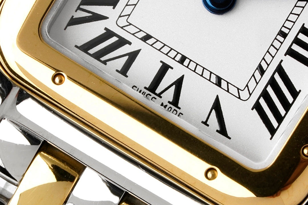Cartier watch dial close-up with Roman numerals and gold bezel edge