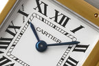 Cartier watch dial close-up showing CARTIER text, blue hand accent, Roman numerals