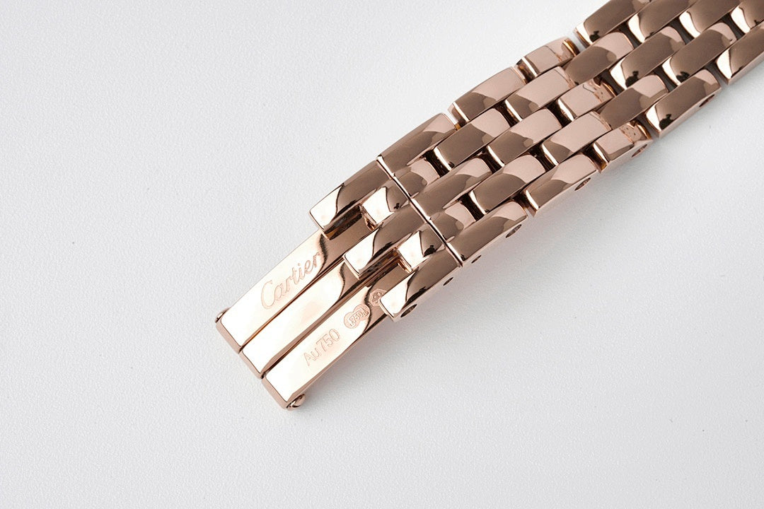 Cartier watch clasp underside on rose gold-tone metal bracelet.