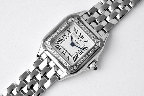Cartier watch with silver link bracelet, gem-set bezel, and blue dial