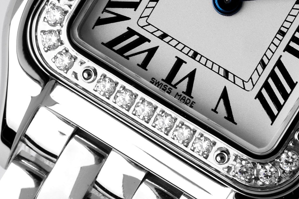 Cartier watch close-up of diamond bezel and Roman numeral dial markers
