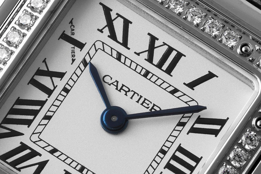 Cartier watch dial close-up with blue hands and Roman numerals