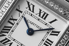 Cartier watch dial close-up with blue hands and Roman numerals