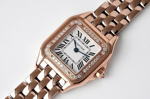 Cartier rose gold watch face with diamond bezel, roman numerals, and linked bracelet