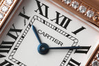 Cartier watch dial close-up with Roman numerals and blue hands