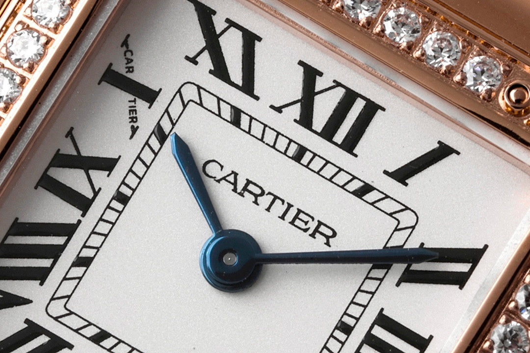 Cartier watch dial close-up with Roman numerals and blue hands