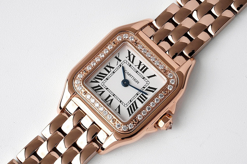 Cartier rose gold watch with diamond bezel, roman numeral dial, and metal bracelet