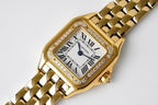 Gold-tone rectangular bezel wristwatch with diamond accents and Roman numeral dial
