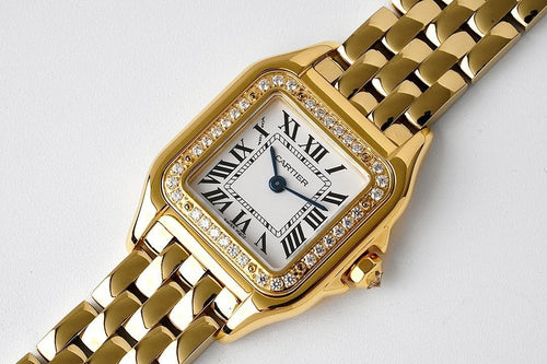 Gold-tone rectangular bezel wristwatch with diamond accents and Roman numeral dial