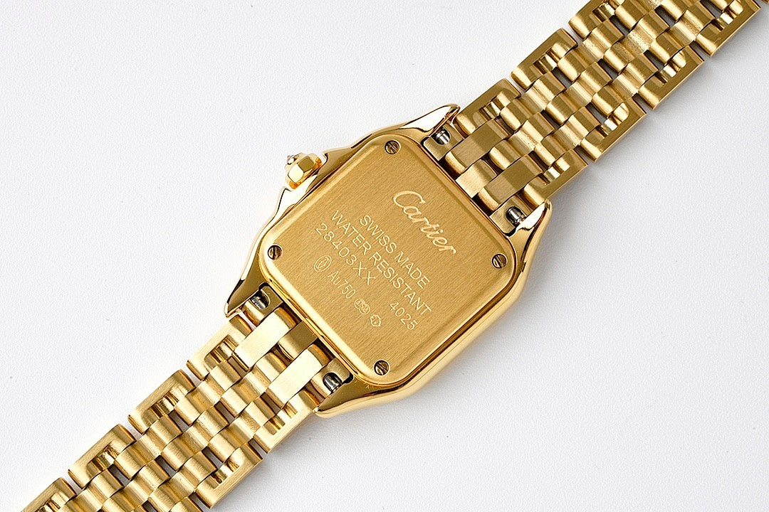 Gold-tone wristwatch caseback with etched details and linked metal bracelet