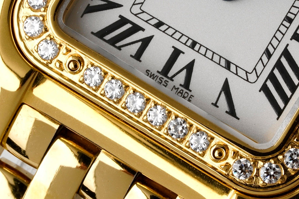 Gold-tone bezel with a row of small stones around a white dial