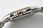 Cartier wristwatch crown area with blue gem accent on polished steel case