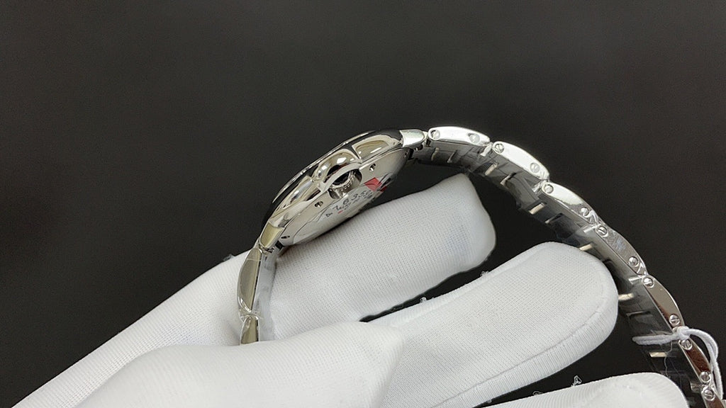 Cartier watch with silver bracelet links and crown, engraved side of case visible