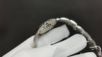 Cartier watch with silver bracelet links and crown, engraved side of case visible