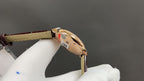 Cartier watch side view with crown, brown leather strap, gold-tone case.
