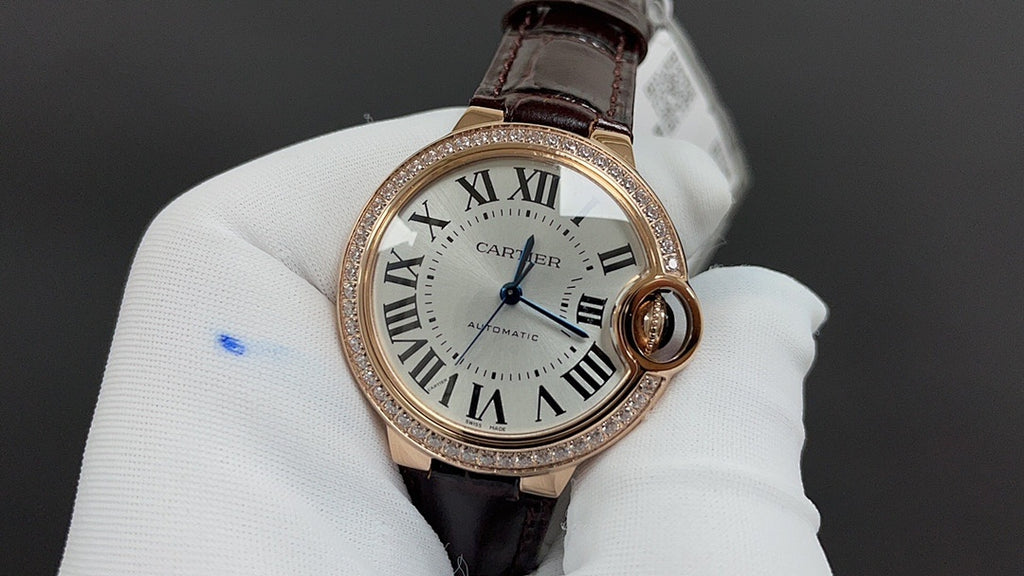 Cartier watch close-up: white dial with Roman numerals, brown leather strap, rose gold bezel.