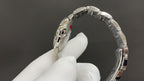 Cartier watch bracelet links and polished case edge in a silver finish.