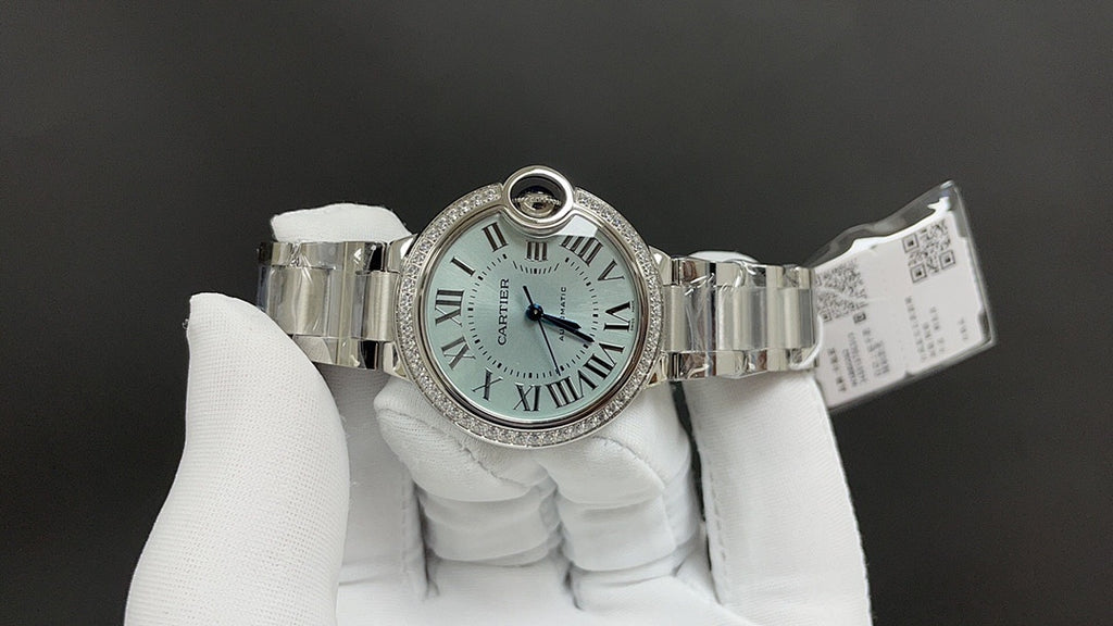 Cartier watch on wristband with open clasp, Roman numeral dial, and diamond bezel.