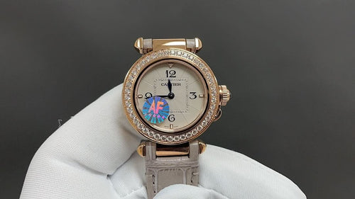Cartier watch with gold-tone case, diamond bezel, cream leather strap, round face