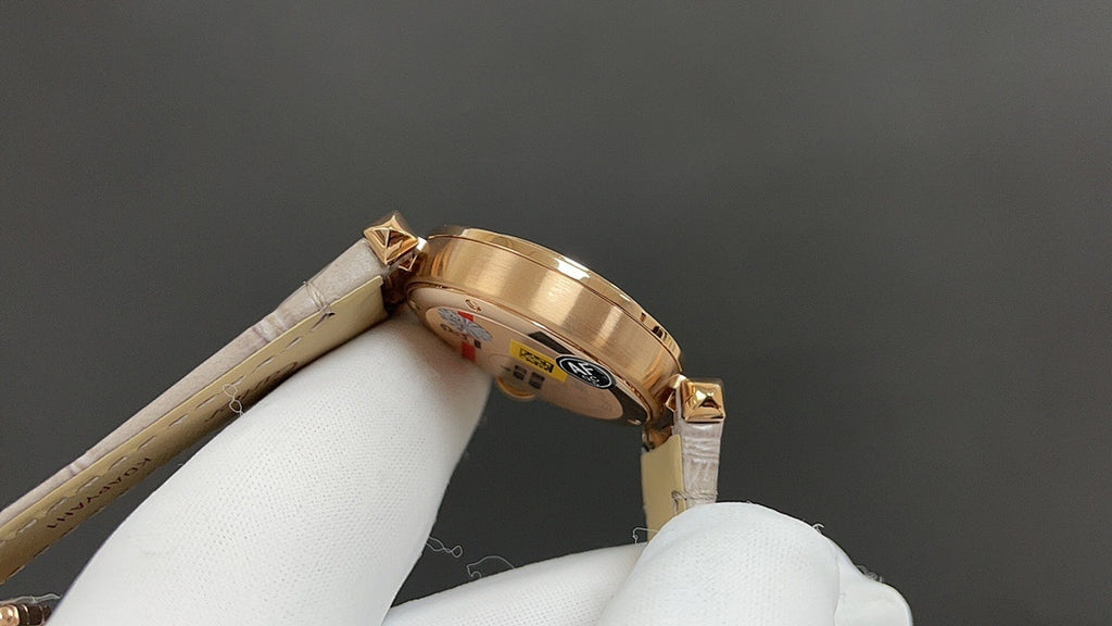 Gold-tone wristwatch with cream leather strap, side profile and crown detail