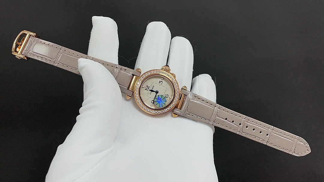 Round-faced wristwatch on a light leather strap with gold-tone case and blue detail