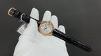 Cartier watch on black leather strap, round rose-gold case with silver dial