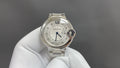 Cartier round wristwatch with silver metal bracelet and white dial, Roman numerals.