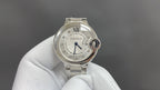 Cartier round wristwatch with silver metal bracelet and white dial, Roman numerals.
