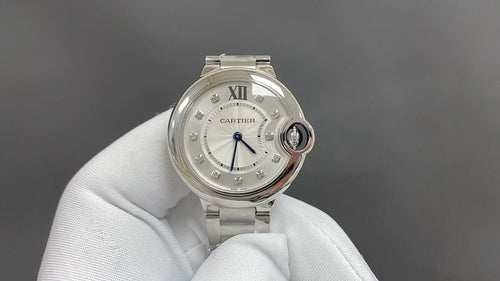 Cartier round wristwatch with silver metal bracelet and white dial, Roman numerals.