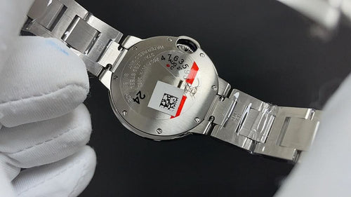 Cartier watch case back with silver bracelet links and marked rear cover.