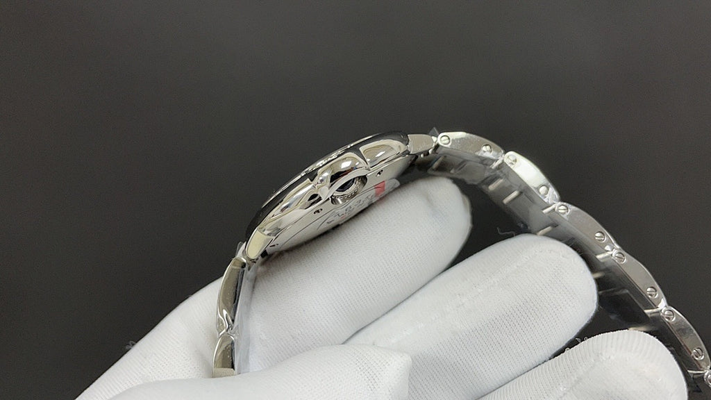 Cartier watch on glove, silver case with Roman numeral dial and crown detail.