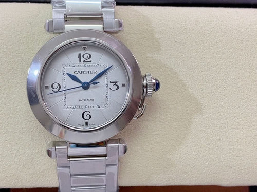 Cartier wristwatch front view with silver dial, blue center hand, stainless steel strap
