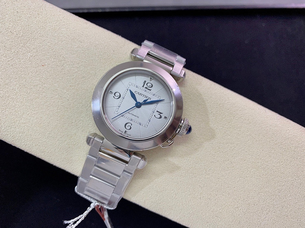 Cartier wristwatch with round silver dial, blue hands, and stainless steel bracelet