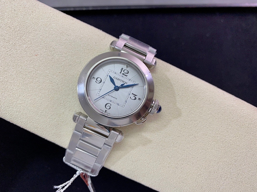 Cartier wristwatch with round silver dial, blue hands, and stainless steel bracelet