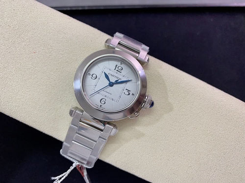 Cartier wristwatch with round silver dial, blue hands, and stainless steel bracelet