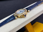 Cartier watch side view with blue leather strap and gold case accents
