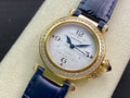Cartier watch with gold case, diamond bezel, blue leather strap, white analog dial