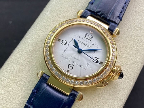 Cartier watch with gold case, diamond bezel, blue leather strap, white analog dial